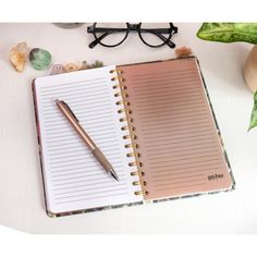 an open notebook with a pen and glasses next to it