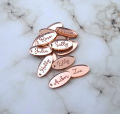 six rose gold personalized name tags on a marble surface with the words happy valentine's day written in cursive font