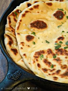 three flat breads in a pan with parsley on top