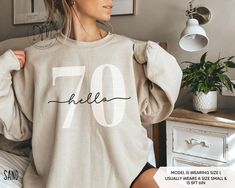 Step into your 70s in retro flair with our Hello 70 sweatshirt! This 70th birthday crewneck is a must-have for commemorating your Seventieth birthday in classic style. It also makes an ideal 70th birthday gift. ✨Please check the SIZE CHART image on the listing, and choose your size accordingly before placing your order.  🚫We do not accept exchanges, returns, or cancellations, however, if there are any print issues with the item please contact us right away. We'll be happy to make things right a Casual Birthday Sweatshirt With Lettering, Casual Sweatshirt With Lettering For Birthday, Hello 60, Hello Thirty, Twenty First Birthday, Sixtieth Birthday, Fifty Birthday, Birthday Sweatshirt, Thirty Birthday