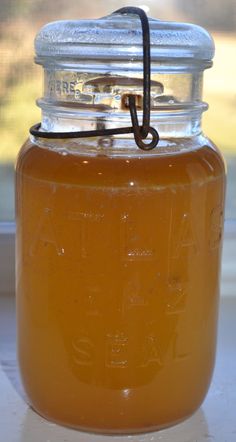 a glass jar filled with liquid sitting on top of a window sill