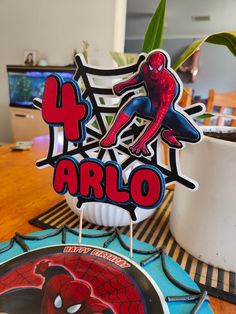 a spiderman cake topper sitting on top of a table