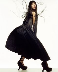 a woman with long black hair is dancing