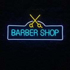 a neon sign that says barber shop with two scissors on it in the dark,