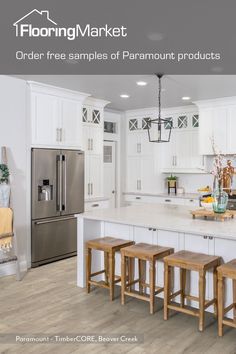 a kitchen with white cabinets and wooden stools in front of an island countertop