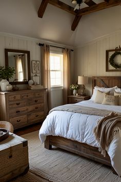 a bed sitting in a bedroom next to a dresser and mirror on top of a wooden floor