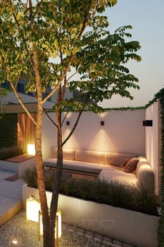 an outdoor living area with couches, trees and lights on the side of the building