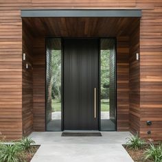 an entrance to a modern home with wood siding