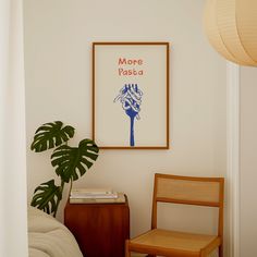 a chair and table in a room with a poster on the wall above it that says more pasta