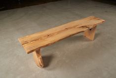 a wooden bench sitting on top of a cement floor