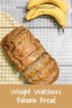 a loaf of bread sitting on top of a cooling rack next to two ripe bananas