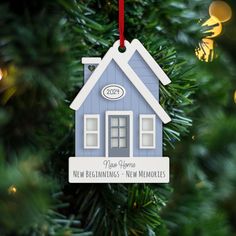 a blue house ornament hanging from a christmas tree