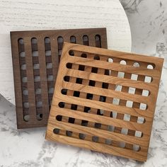 two wooden grates sitting on top of a marble counter