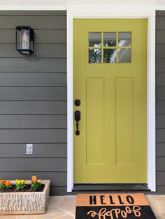 a yellow door with hello hope written on it and two flower pots in front of it