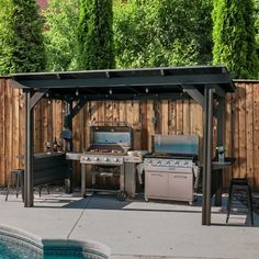 an outdoor bbq with grills and chairs next to a pool in the backyard