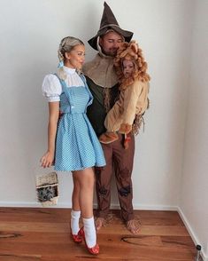 a man and woman dressed up as wizard and scarecrows, standing next to each other