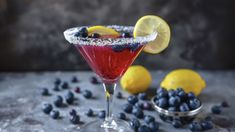 a glass filled with blueberries and lemons on top of a gray countertop