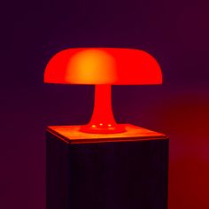 a red lamp sitting on top of a wooden block