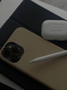 a cell phone sitting on top of a table next to a pen and an electronic device