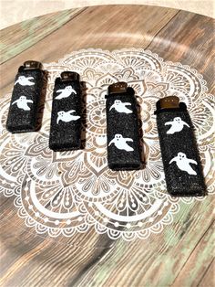 four black and white lighters sitting on top of a wooden table