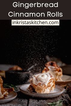 cinnamon rolls are being sprinkled with icing on a plate and surrounded by other desserts