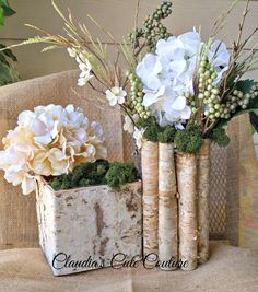 two vases filled with flowers sitting on top of a couch next to each other