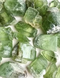 some green crystals are on a white surface