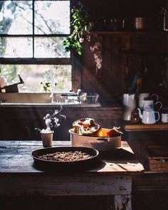 a table with food on top of it in front of a window and potted plant