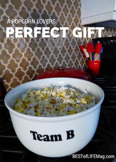 a bowl filled with popcorn sitting on top of a stove