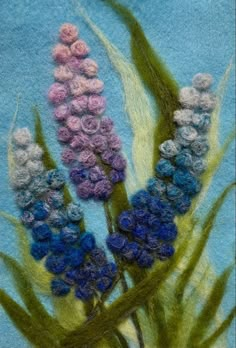 needled flowers on blue background with green stems and purple flowers in the center, closeup