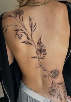 a woman's back with flowers and leaves on it