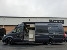 a van parked in front of a building with its doors open and the door ajar