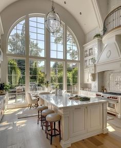 a large kitchen with an arched ceiling and two windows overlooking the backyard area is shown