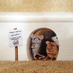 two mouses sitting in front of a sign that says no cats on the door