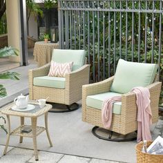 two wicker chairs and a table on a patio