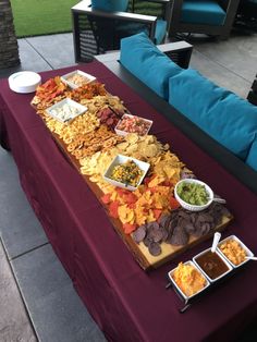 a long table with many different types of food on it, including chips and dips