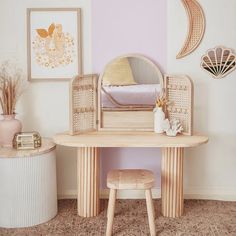 a wooden desk with a mirror, stool and pictures on the wall in a child's bedroom