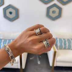 a woman's hand holding three different rings