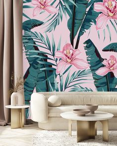 a living room with pink flowers and palm leaves on the wall next to two tables