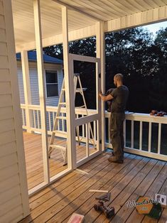 a man standing on top of a wooden deck next to a white door and window