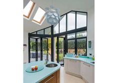 a kitchen with blue counter tops and an open skylight over the sink area is shown