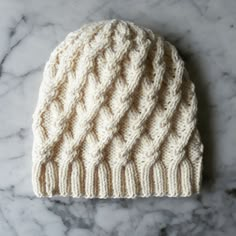 a white knitted hat sitting on top of a marble counter