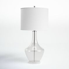 a clear glass table lamp with a white shade