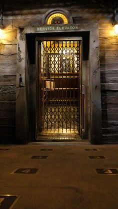 the entrance to an old building at night with lights on and no people in it