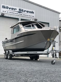 a silver boat is parked in front of a building with a sign that says silver streak