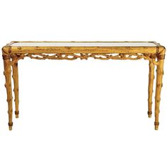 an antique console table with glass top and wooden legs, in the style of bamboo