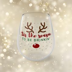 a wine glass that says it's the season to be drinkin with reindeer antlers on it