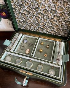 an open green box with jewelry in it