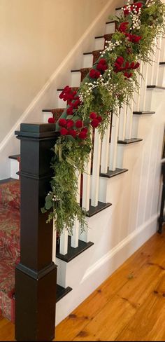 a set of stairs decorated with flowers and greenery next to a stair case in a home