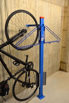 a bicycle is mounted to a blue bike rack